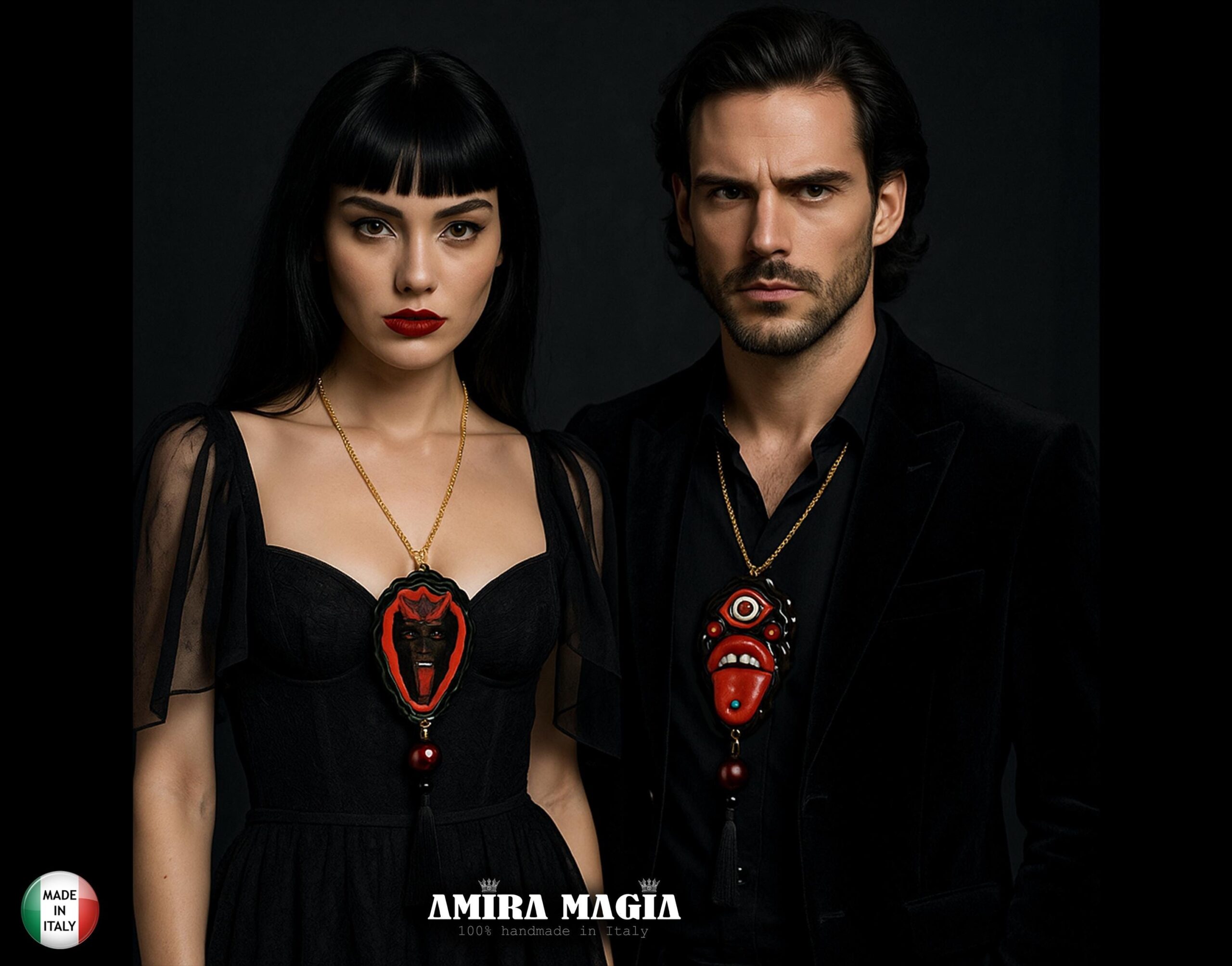A woman and a man in black attire wearing ornate red, black, and gold pendants, against a dark background with branding text at the bottom.